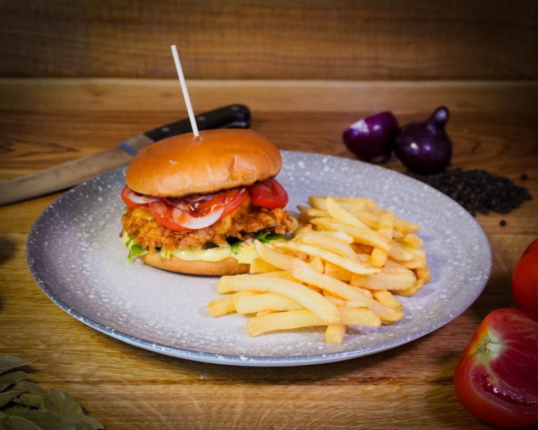 Cheeseburger de pui cu cartofi prăjiți, preparat la restaurantul Pensiunii Denis din Cătina